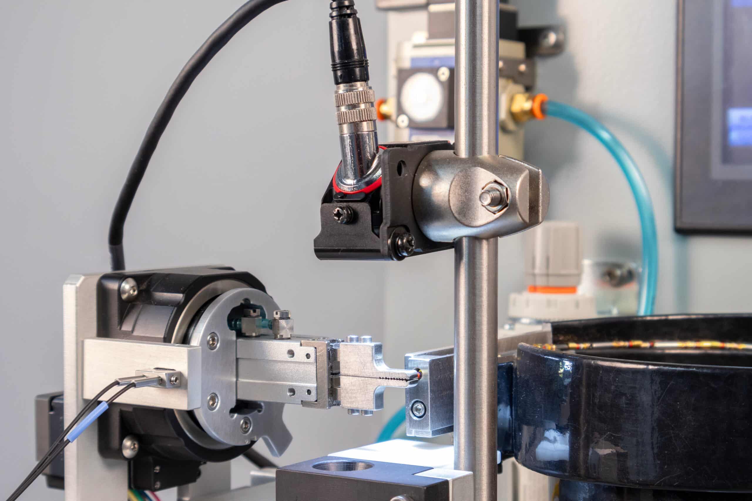 A close-up of the front of the Tri-Star Technologies TAC-ULTRA automatic wire crimping system's camera and gripper system.