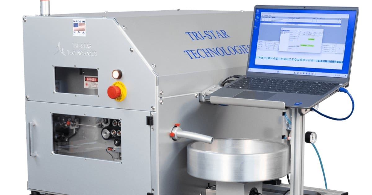A close-up of the Tri_Star Technologies industrial laser marking system with a laptop against a blank background.