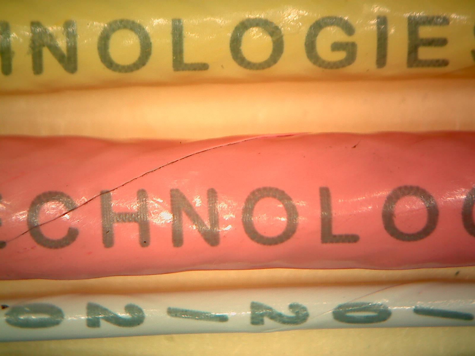 A close-up of various colored wires, in yellow, red, and grey, with sample markings from Tri-Star Technologies systems.