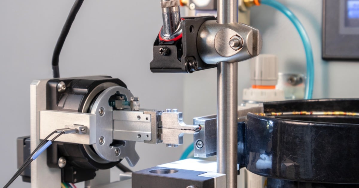 A close-up of the camera and gripper system of the Tri-Star Technologies TAC-ULTRA automatic crimper.